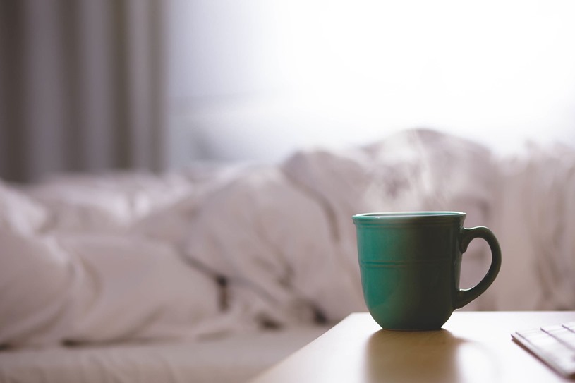 hot coffee mug next to bed