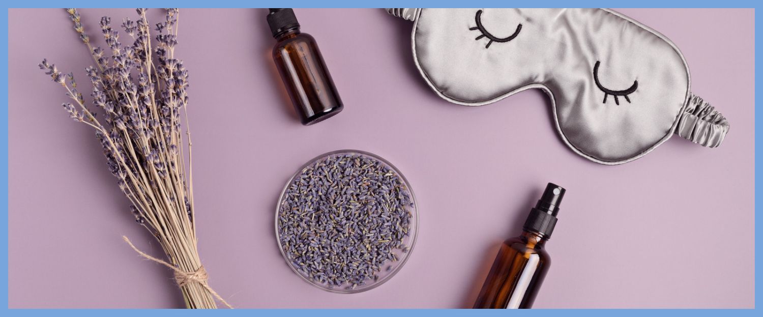 lavender oil, lavender and a sleep mask laying flat on a table