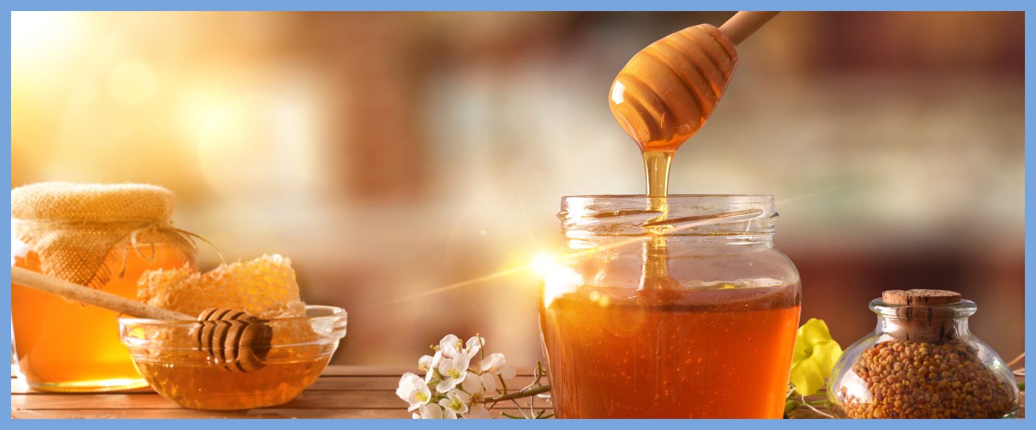 honey on a table dripping into a glass jar