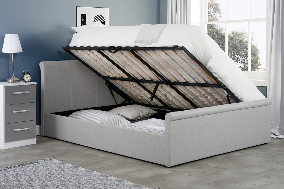 Stratus grey fabric ottoman bed with the base raised on its gas lift, showing the sprung slats and storage underneath