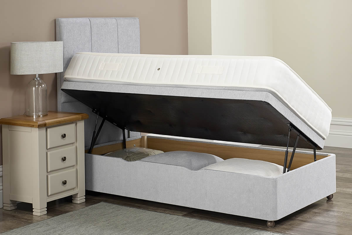 Side lift ottoman divan base opened from one side, next to a bedside table